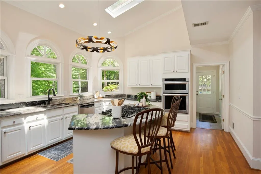 A bright and open layout highlights the oversized island with seating, creating an inviting space for casual dining and gathering.