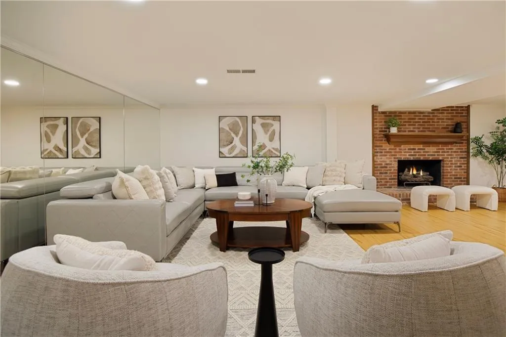 The expansive terrace level living area offers a comfortable and stylish gathering space, complete with a cozy brick fireplace and abundant seating.