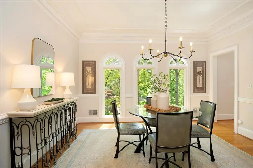 The dining room is both elegant and inviting, framed by tall windows with peaceful wooded views—perfect for intimate dinners or larger gatherings.
