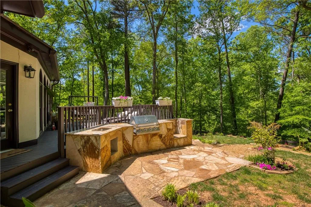 Thoughtfully designed for entertaining, the outdoor grilling area is complemented by a stone patio and seamless access to the deck.