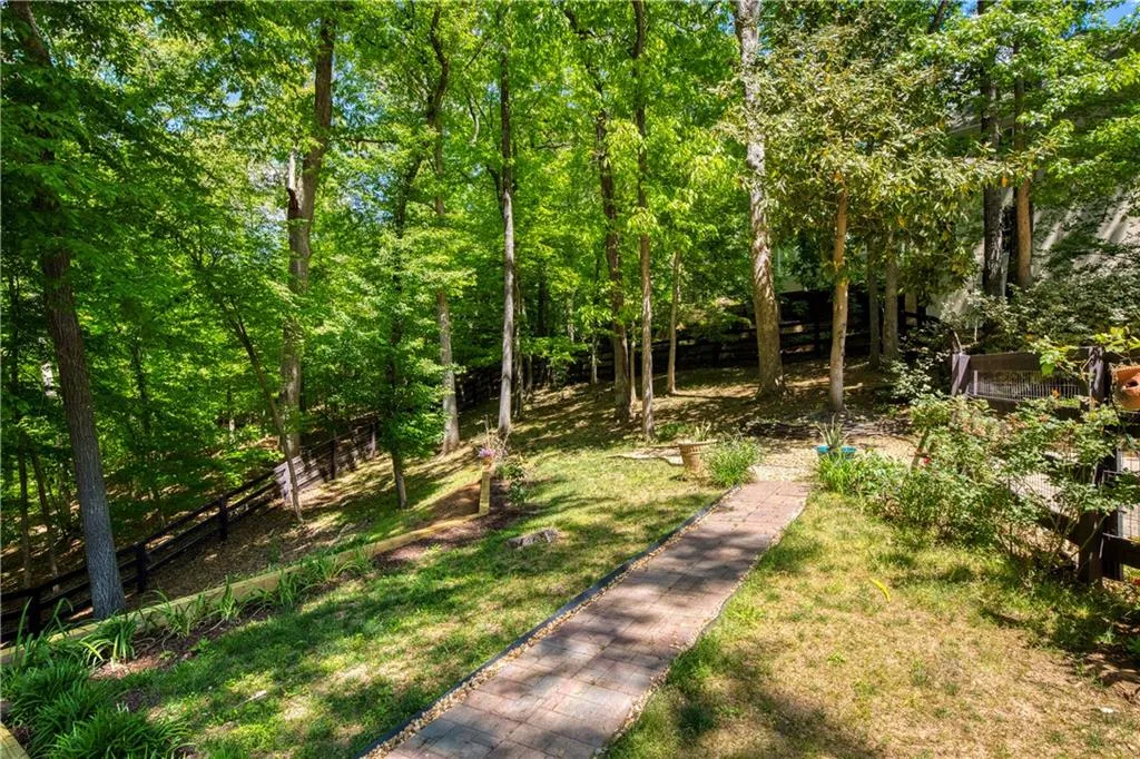 The expansive, wooded backyard offers both privacy and a connection to nature, enhancing the home’s retreat-like feel.