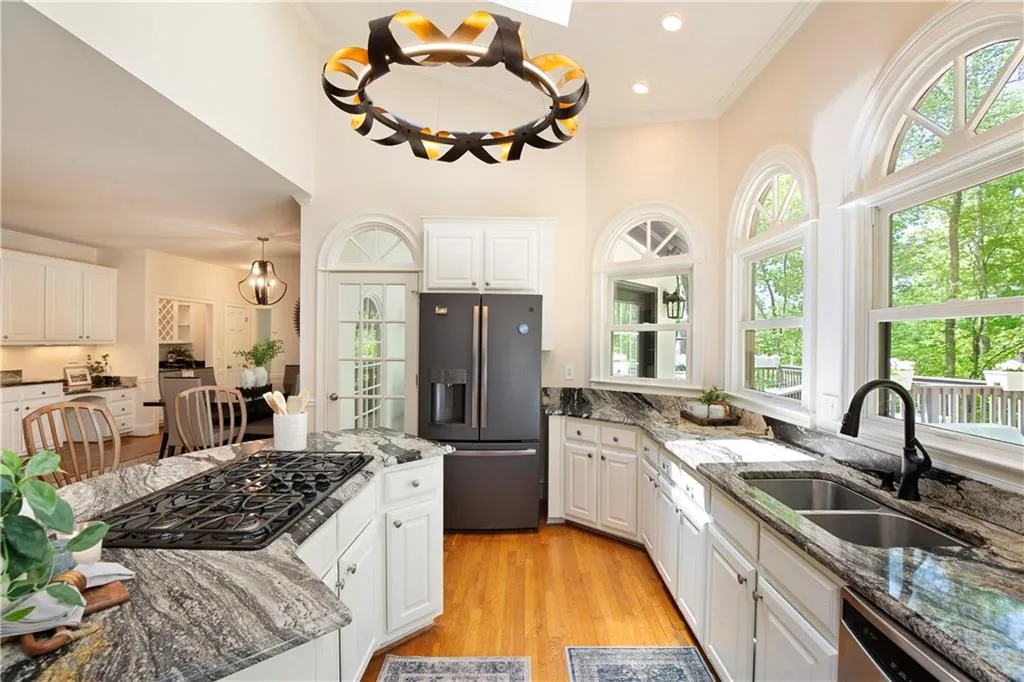 The kitchen is bright and inviting, featuring granite countertops, a generous island with seating, and abundant cabinetry.