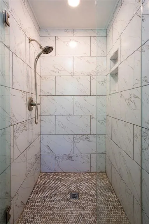 The walk-in shower is beautifully updated with sleek tilework and a glass enclosure, creating a clean and modern feel.
