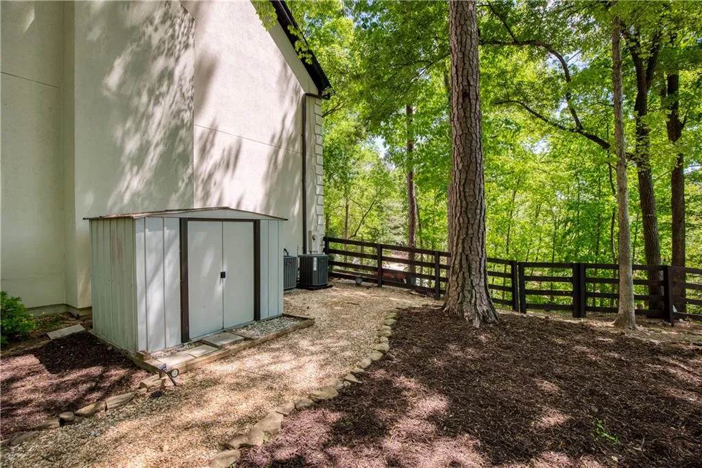 A discreet storage area and well-maintained grounds add everyday functionality while preserving the home’s natural setting.