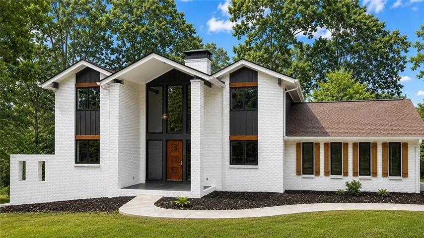 White brick exterior with a dark shingle roof