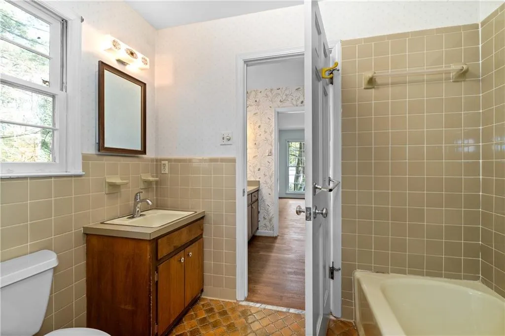 Divided main floor master bathroom has two vanity areas and separate area for bathing