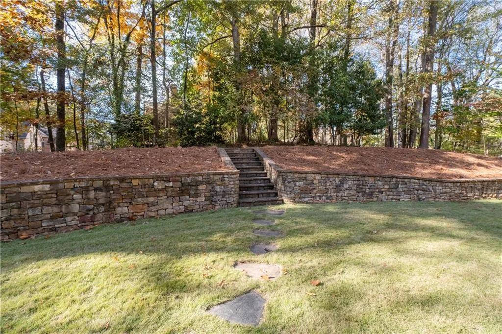 Gorgeous stone wall and stairs lead to upper yard! Mature shrubs and trees!