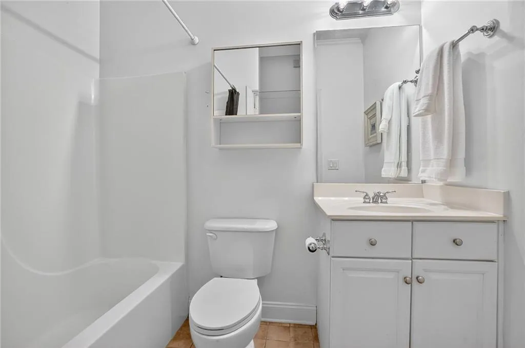 Bathroom with vanity, tile patterned flooring, and tub / shower combination