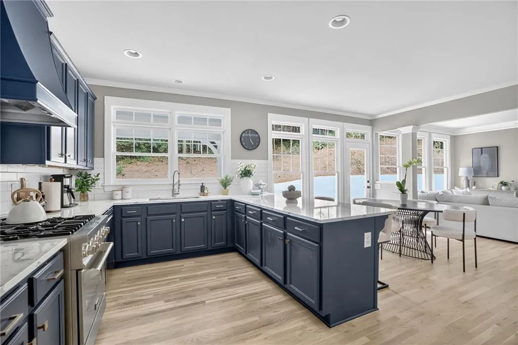 Kitchen with gas range, custom exhaust hood, decorative backsplash, ornamental molding, and a peninsula