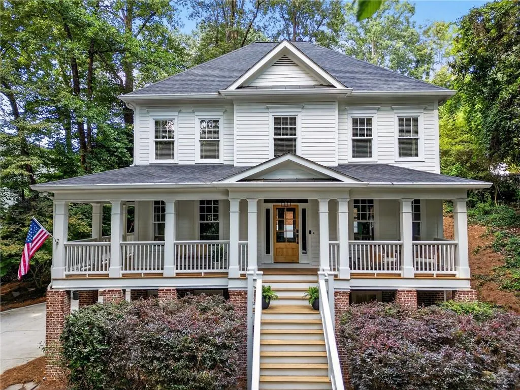 View of front of house with roof with shingles, stairs, and covered porch