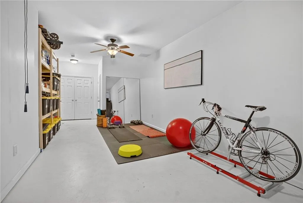Exercise room with baseboards and a ceiling fan