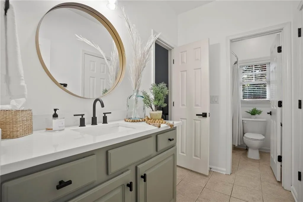 Bathroom featuring vanity, tile patterned flooring, and curtained shower