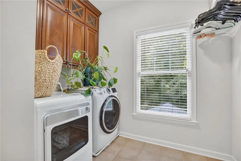 Laundry area featuring washing machine and dryer and light tile patterned floors