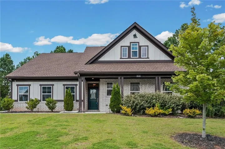 Craftsman-style home featuring a mixed-material facade with light brick and board-and-batten siding
