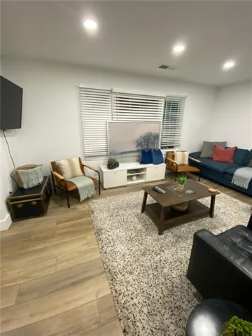 Recessed ceiling lighting, wood-finish flooring, white baseboards, and window blinds