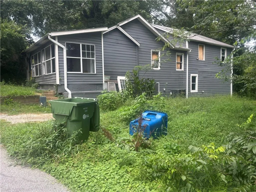 Rear view of property with view of scattered trees