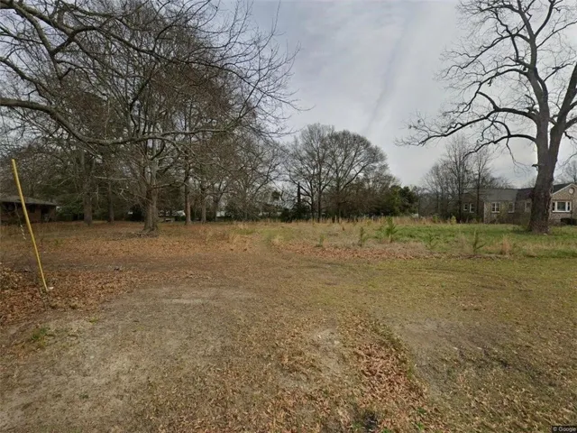 Expansive land parcel featuring existing mature trees and a flat topography