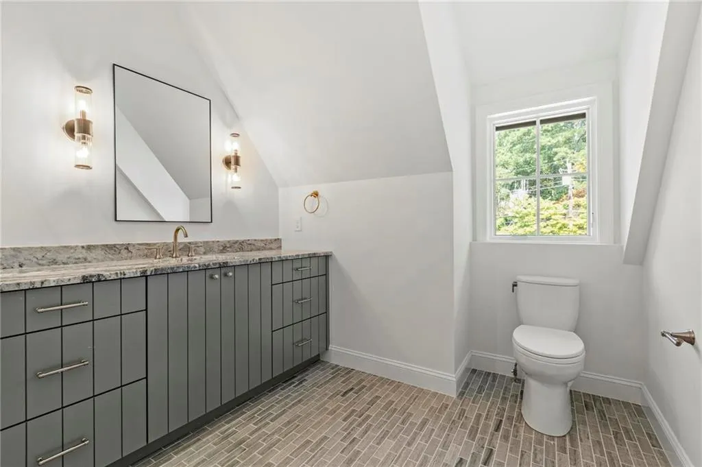 Bathroom featuring vanity and lofted ceiling