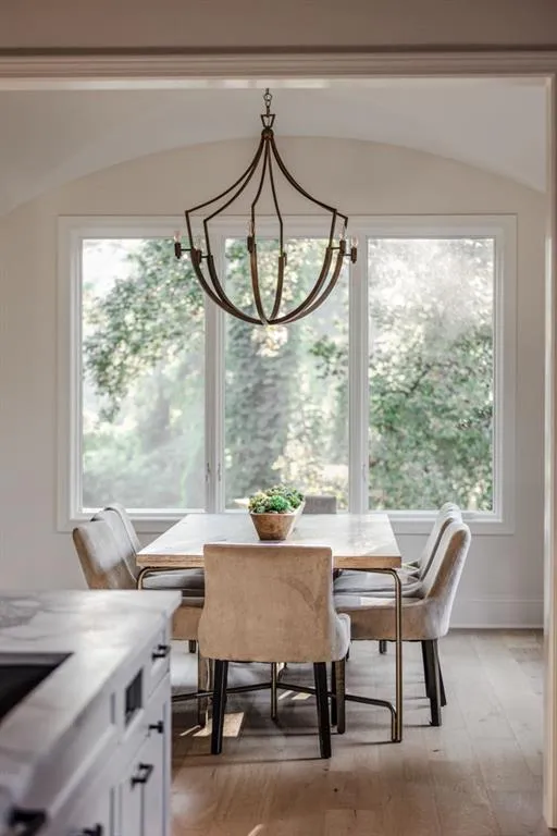 Dining space with healthy amount of natural light, light wood-type flooring, and a chandelier