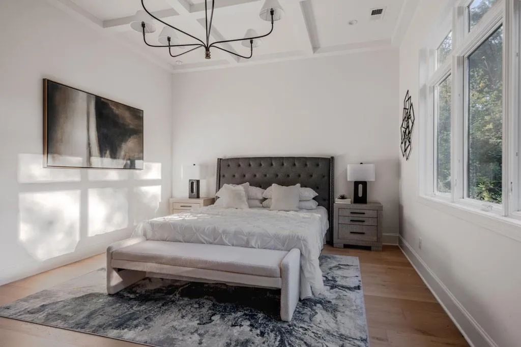 Bedroom featuring wood finished floors, coffered ceiling, beam ceiling, and a chandelier