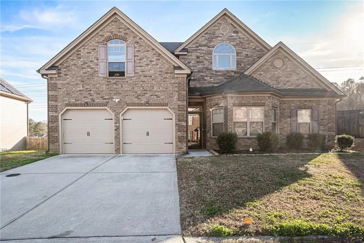 Brick exterior with stone accents, arched windows, and a two-car garage