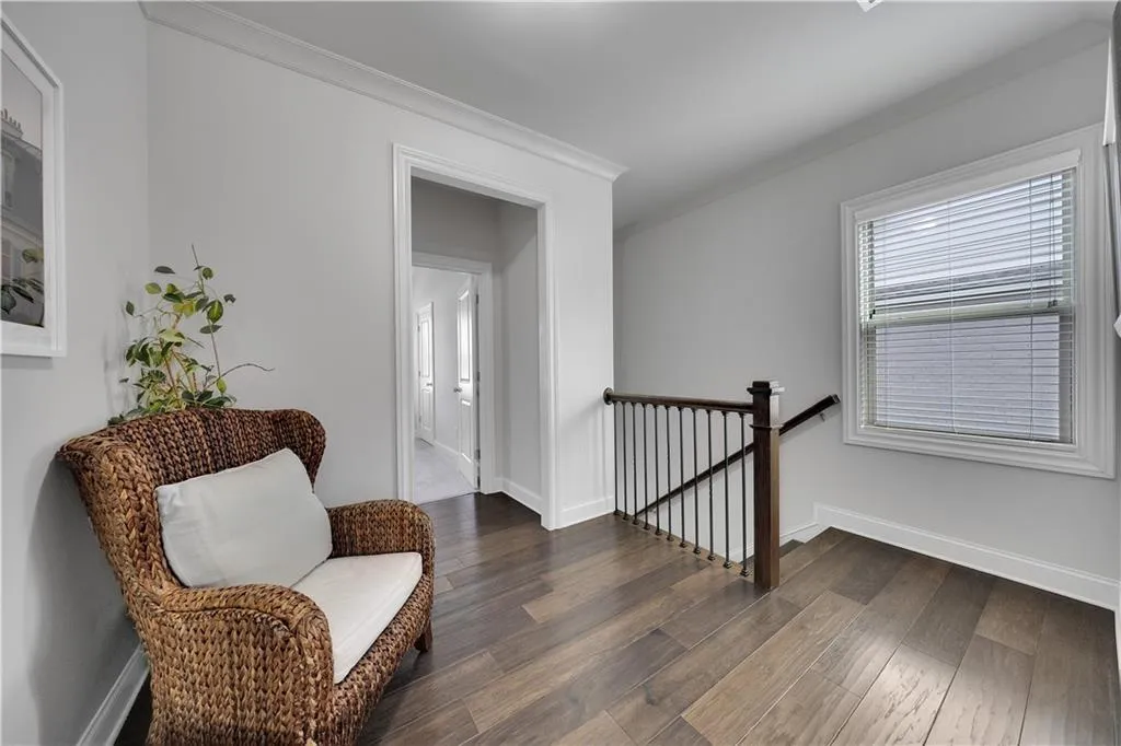 Living area featuring an upstairs landing, crown molding, and wood finished floors