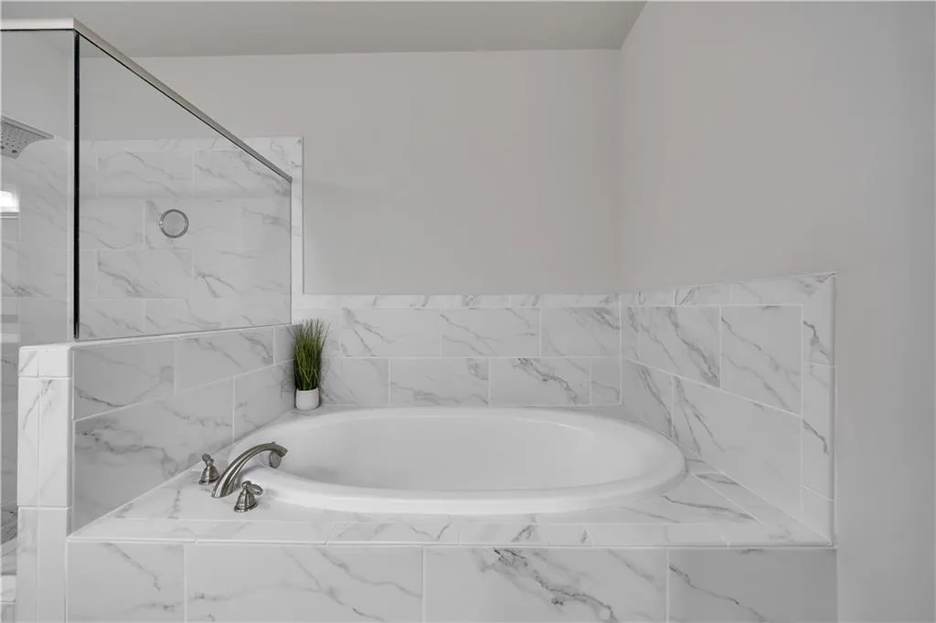 Bathroom with a bath and a marble finish shower
