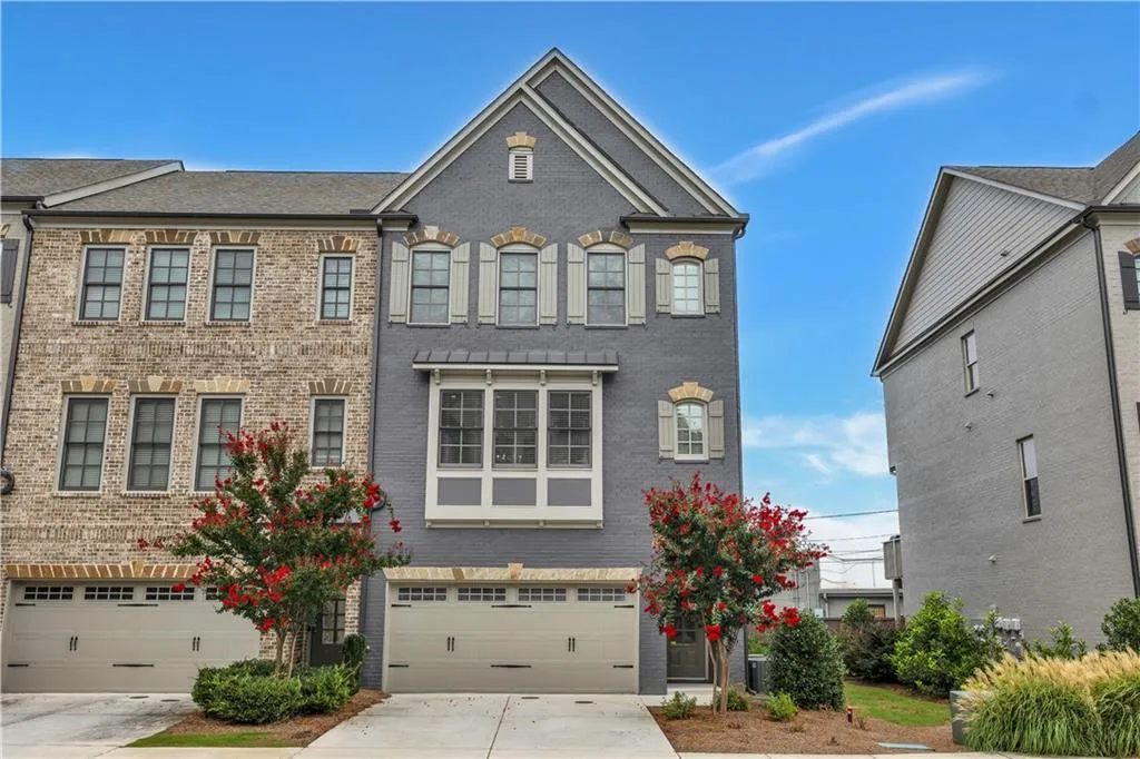 View of front facade featuring brick siding, an attached garage, and driveway