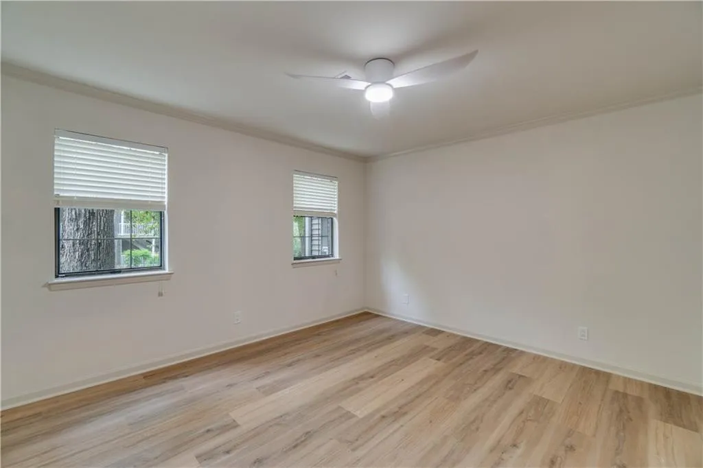 Unfurnished room featuring ceiling fan, light hardwood / wood-style floors, and crown molding