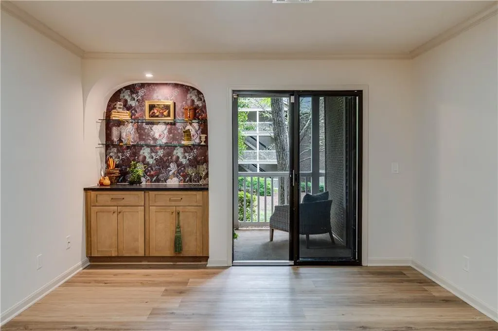 Doorway to outside with ornamental molding and light hardwood / wood-style floors