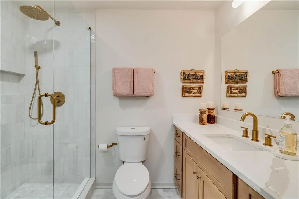 Bathroom with large vanity, an enclosed shower, toilet, and tile flooring