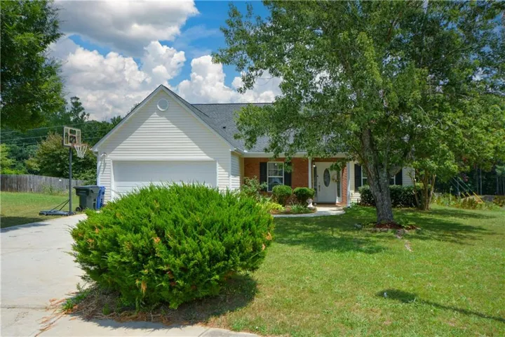 Traditional-style home featuring a covered front porch, white siding, and a single-car garage