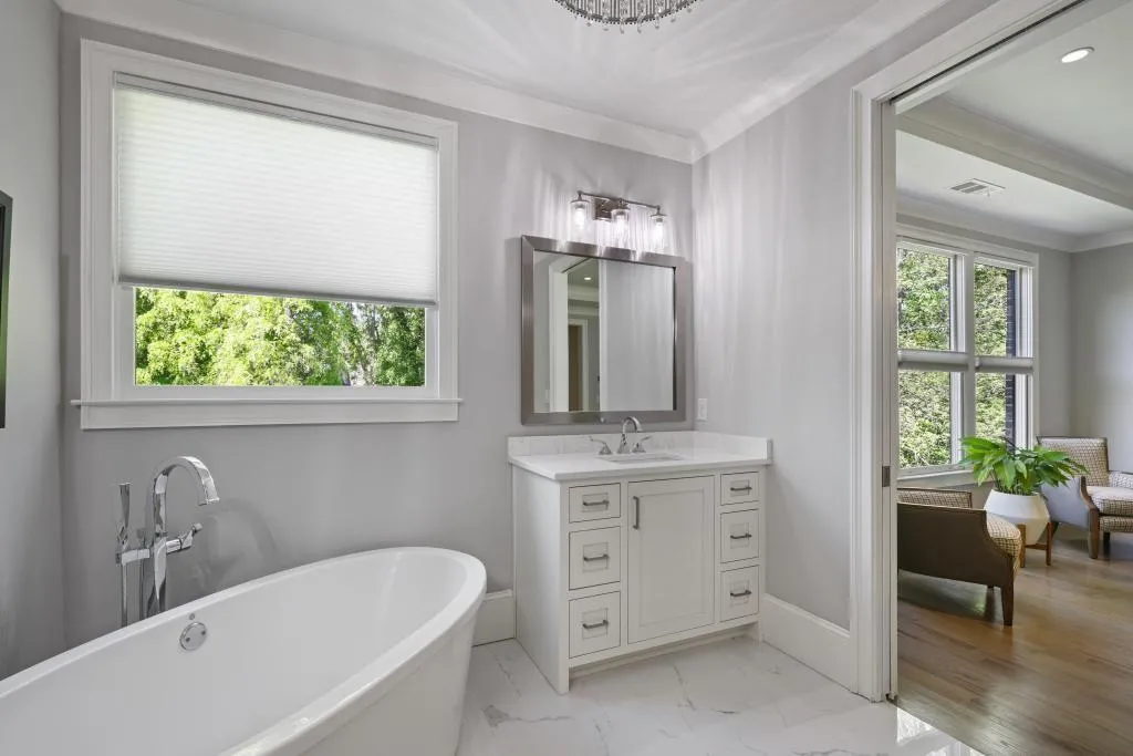 Bathroom with vanity, a soaking tub, and light marble finish flooring