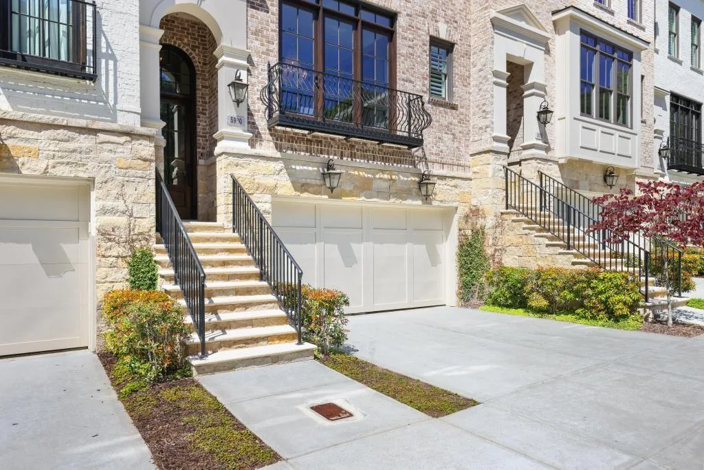 Property entrance featuring an attached garage, concrete driveway, and stone siding