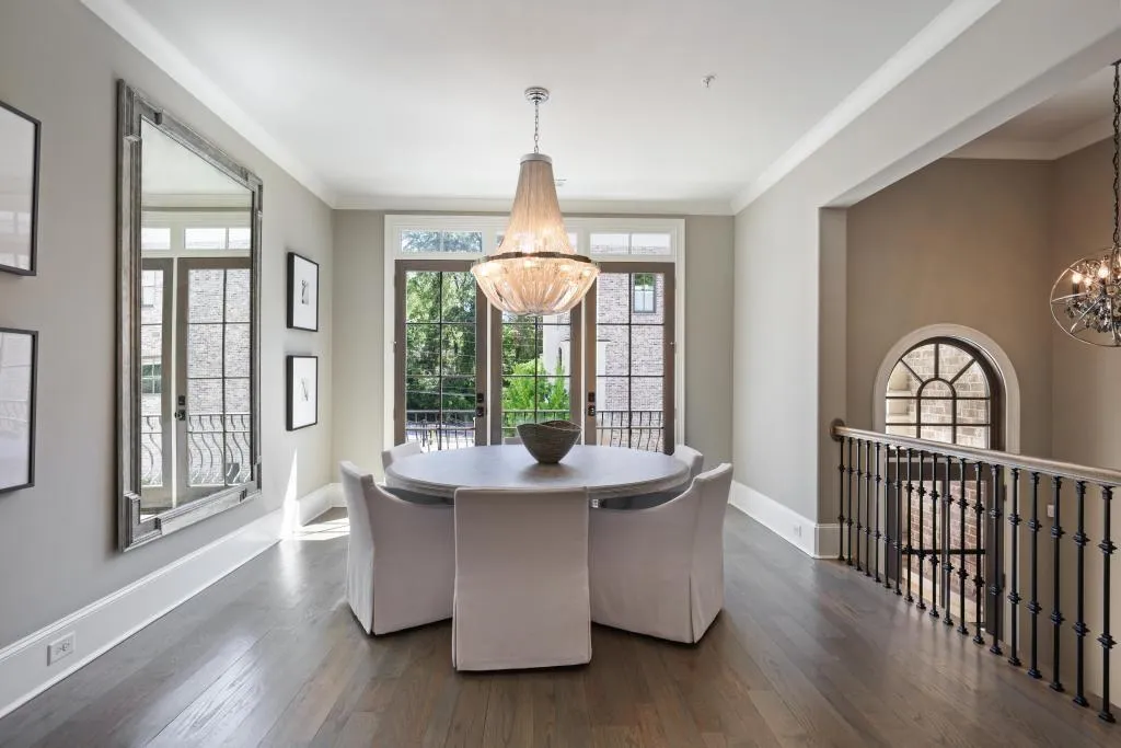 Dining room with hanging lights, crown molding, and dark wood-type flooring
