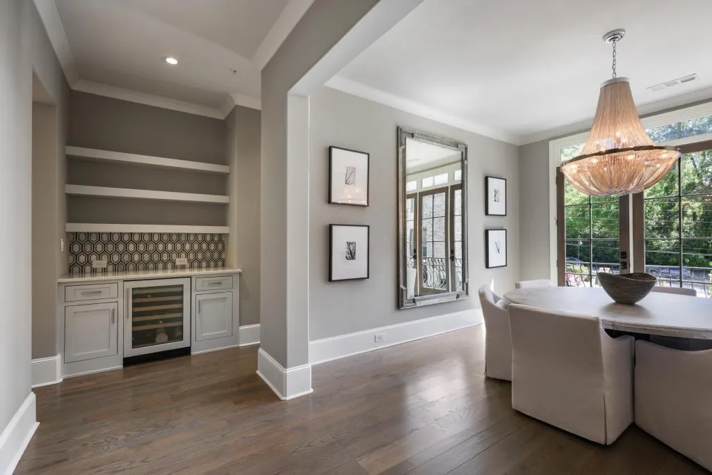 Dining room featuring crown molding, beverage cooler, built in shelves, dark wood finished floors, and a bar