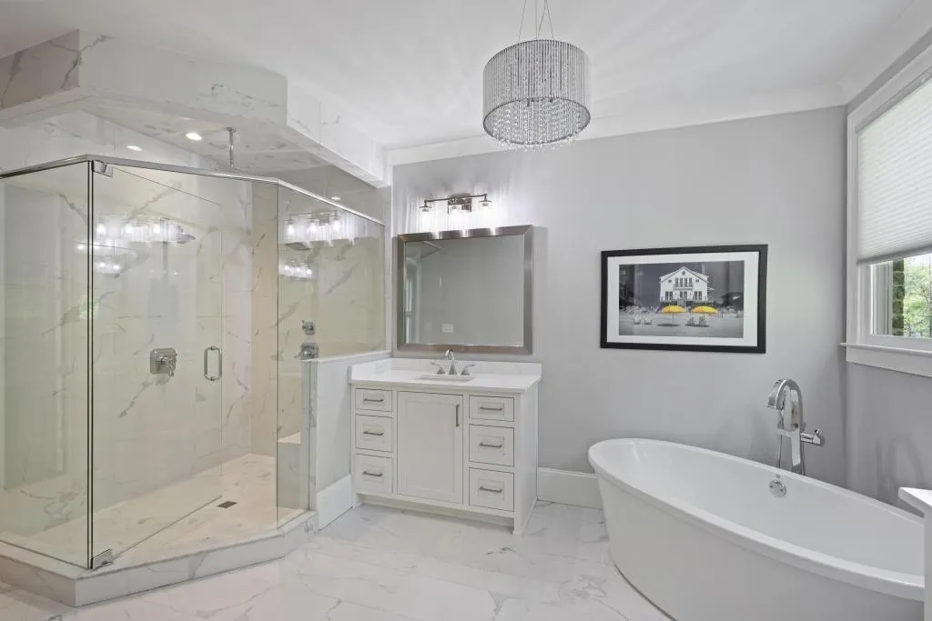 Full bath featuring a marble finish shower, vanity, a freestanding bath, light marble finish flooring, and a chandelier