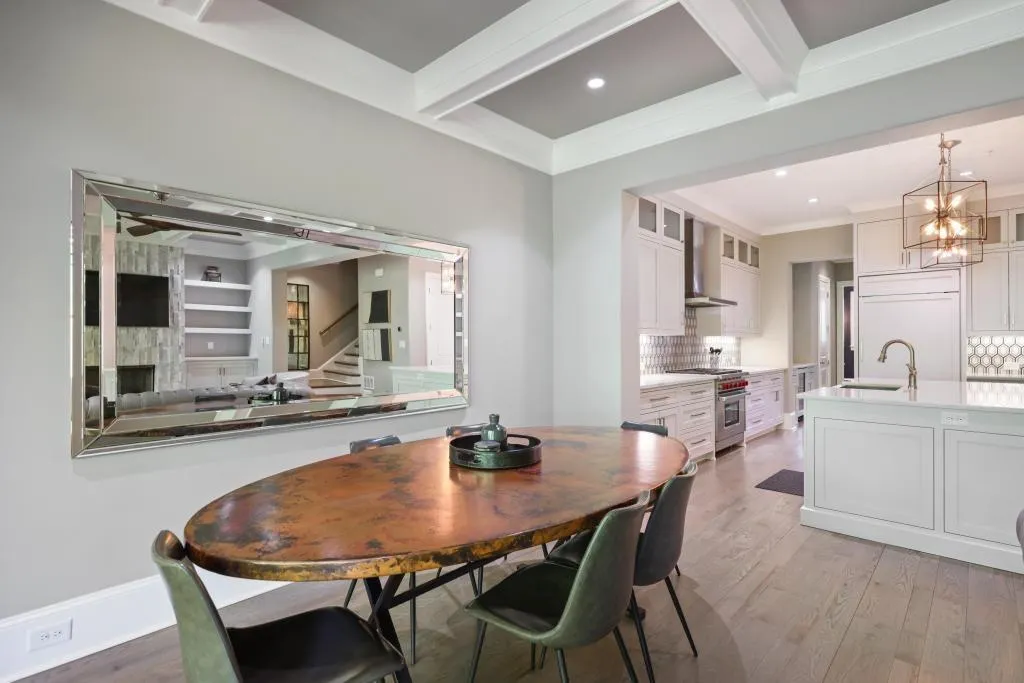 Dining space with light wood-style flooring, beam ceiling, a chandelier, and crown molding