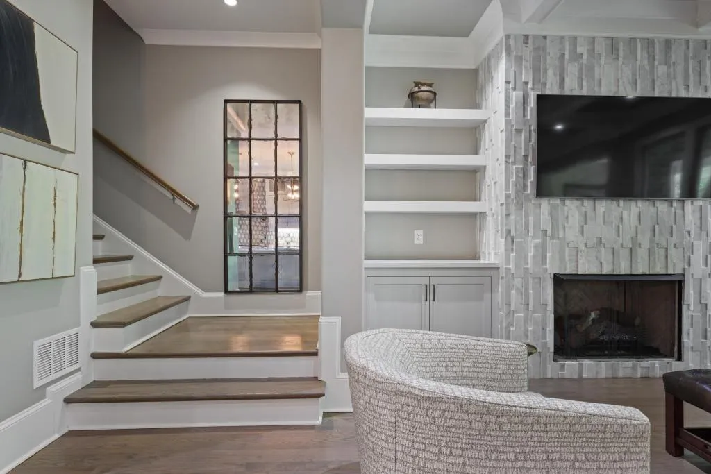 Stairs with built in shelves, wood finished floors, and a fireplace