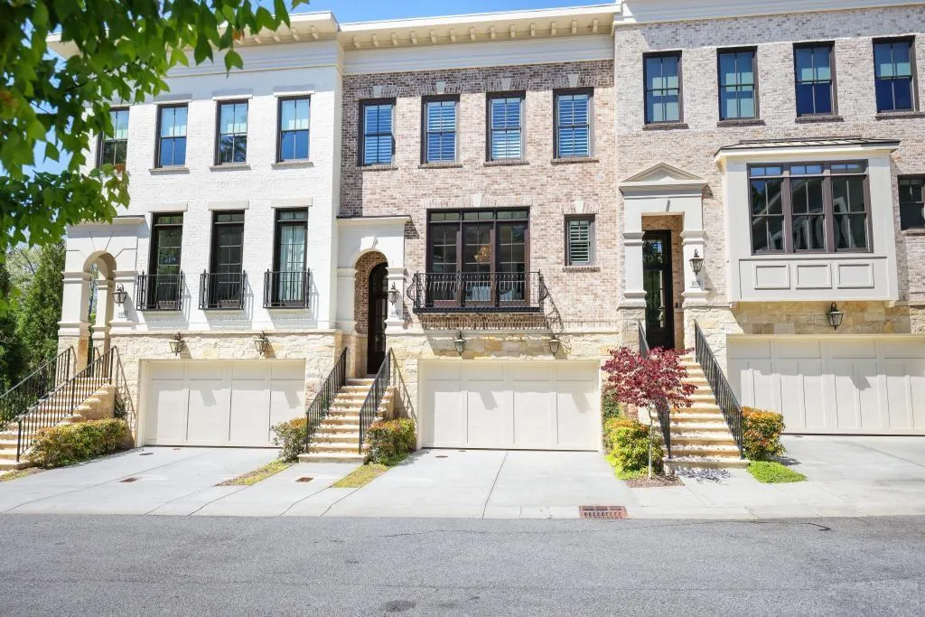 View of front of property featuring a garage, concrete driveway, and brick siding