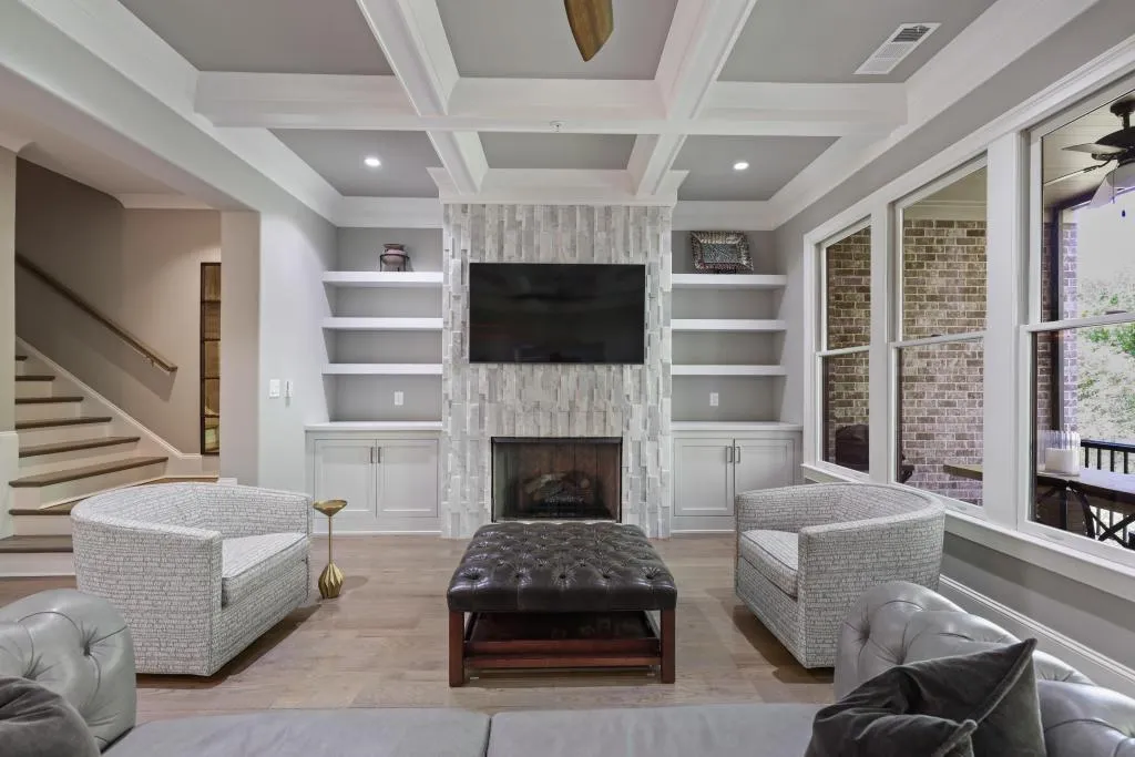 Living room with a ceiling fan, wood finished floors, a fireplace, coffered ceiling, and recessed lighting