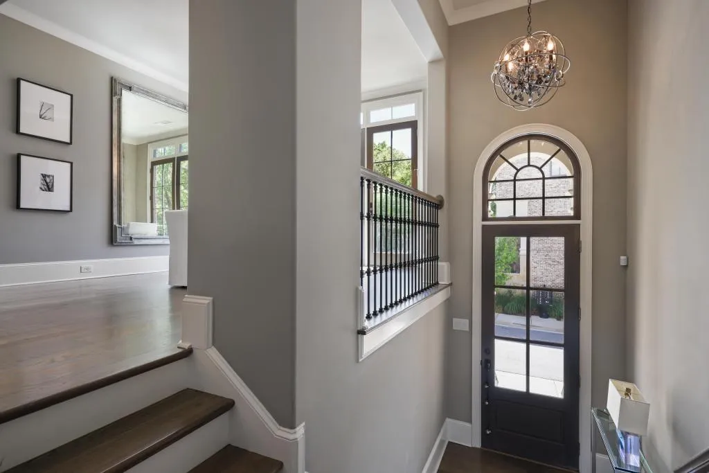 Foyer entrance with suspended lighting and dark wood-style floors