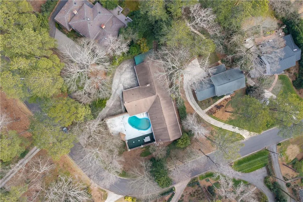 Aerial view of property and surrounding area featuring a pool