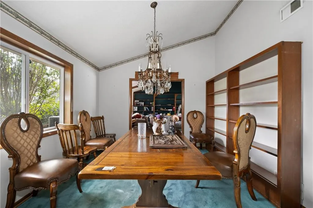 Dining space with crown molding, a chandelier, and lofted ceiling