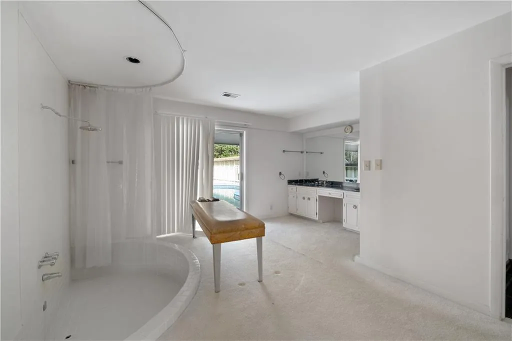 Full bath featuring a shower with shower curtain, vanity, and light colored carpet