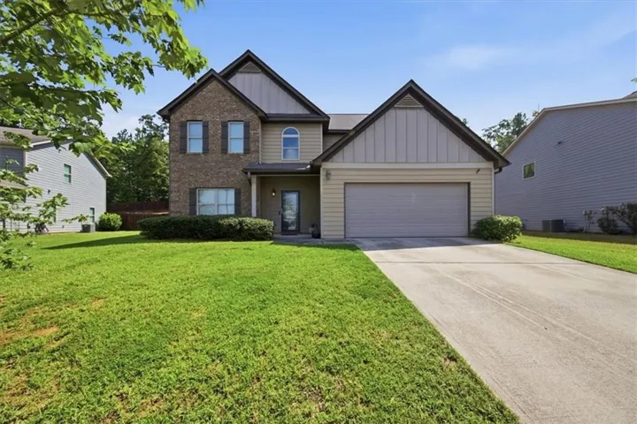 Two-story residence featuring a brick and siding exterior, an attached two-car garage, and a concrete driveway