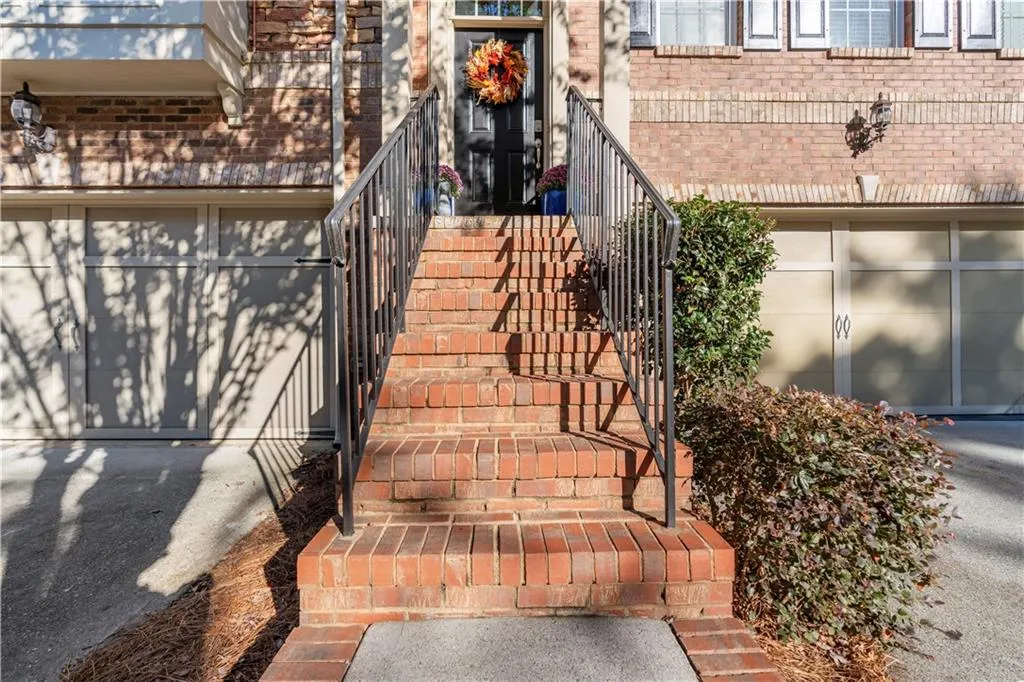 View of exterior entry with a garage and brick siding