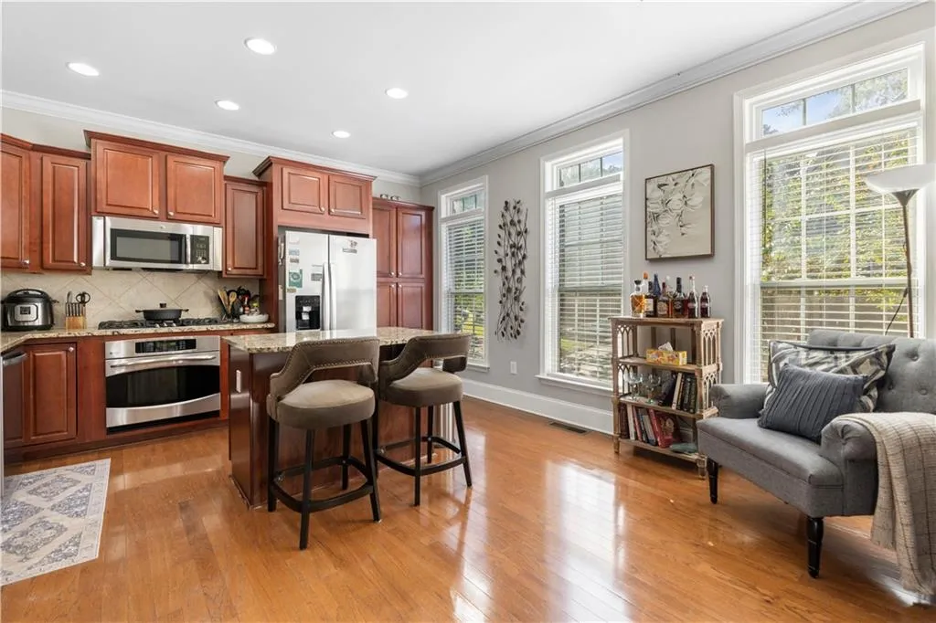Kitchen featuring crown molding, appliances with stainless steel finishes, a kitchen island, healthy amount of natural light, and tasteful backsplash