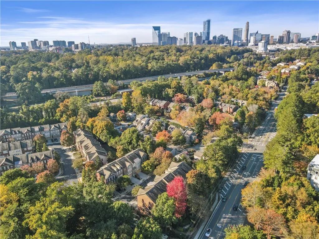 Aerial view of property's location featuring a tree filled landscape and city skyline