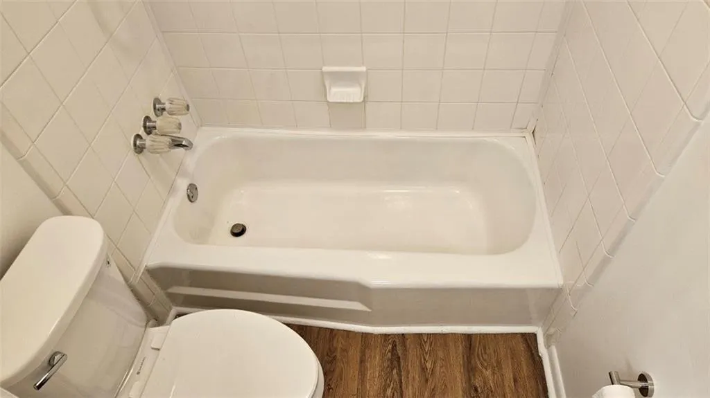 Bathroom featuring wood finished floors and shower / tub combination